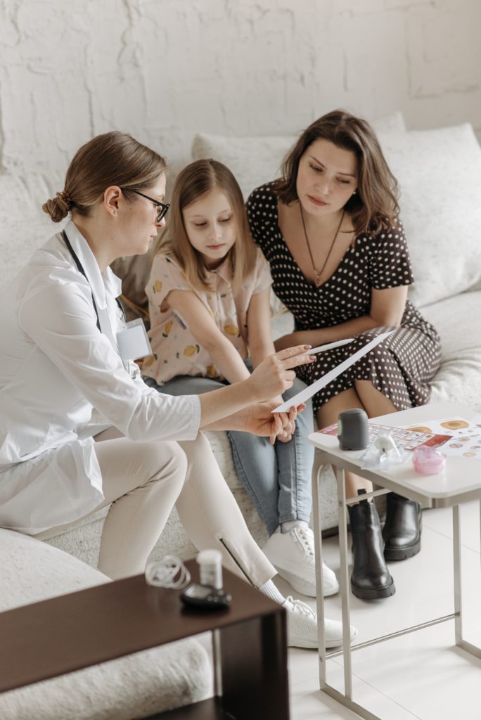 doctor explaining treatment to a child and her mother